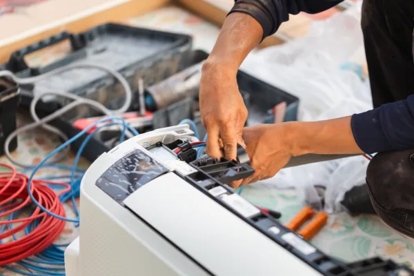 Representative image of hands servicing residential HVAC equipment
