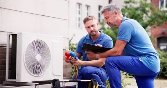 Representative image of two HVAC professionals reviewing an outdoor cooling system